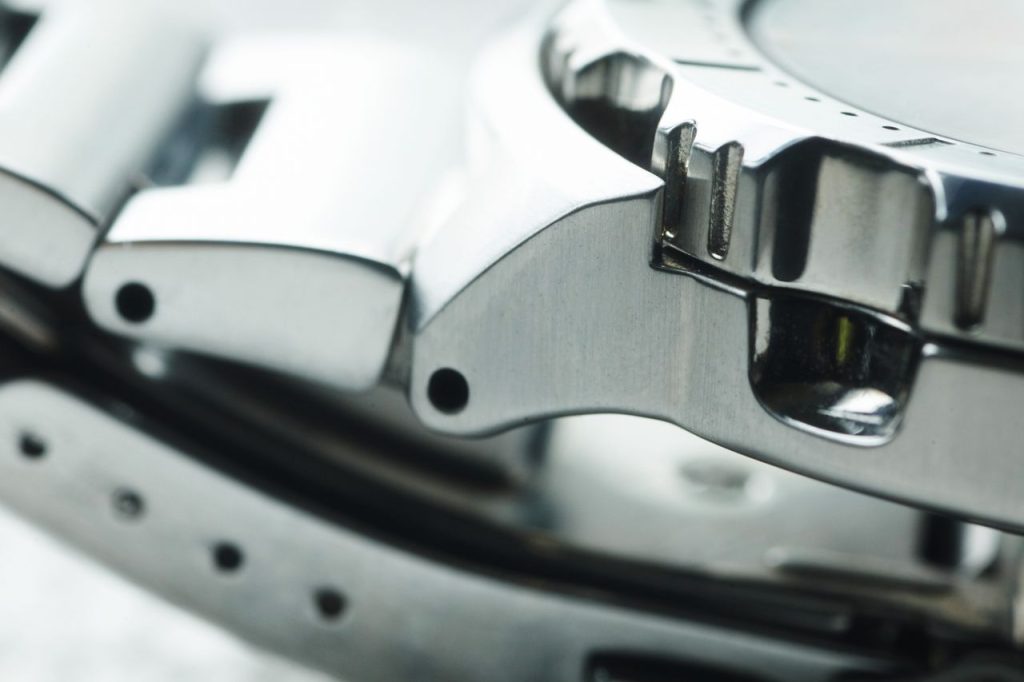 Detailed close-up of a metallic watch band showcasing modern and shiny design elements.